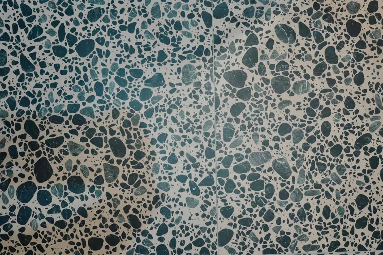 Close-up of blue terrazzo wall tiles with contemporary stone pattern finish.