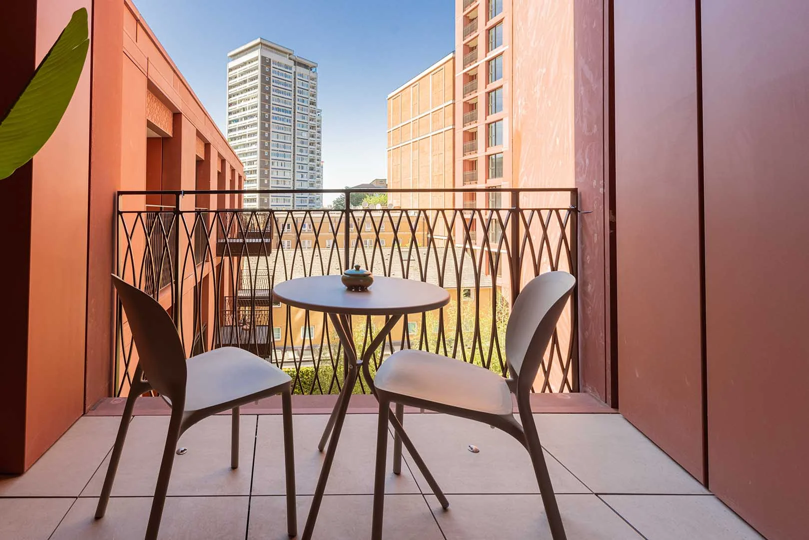 Private apartment balcony with outdoor seating overlooking modern residential buildings at West End Gate, Paddington, London.