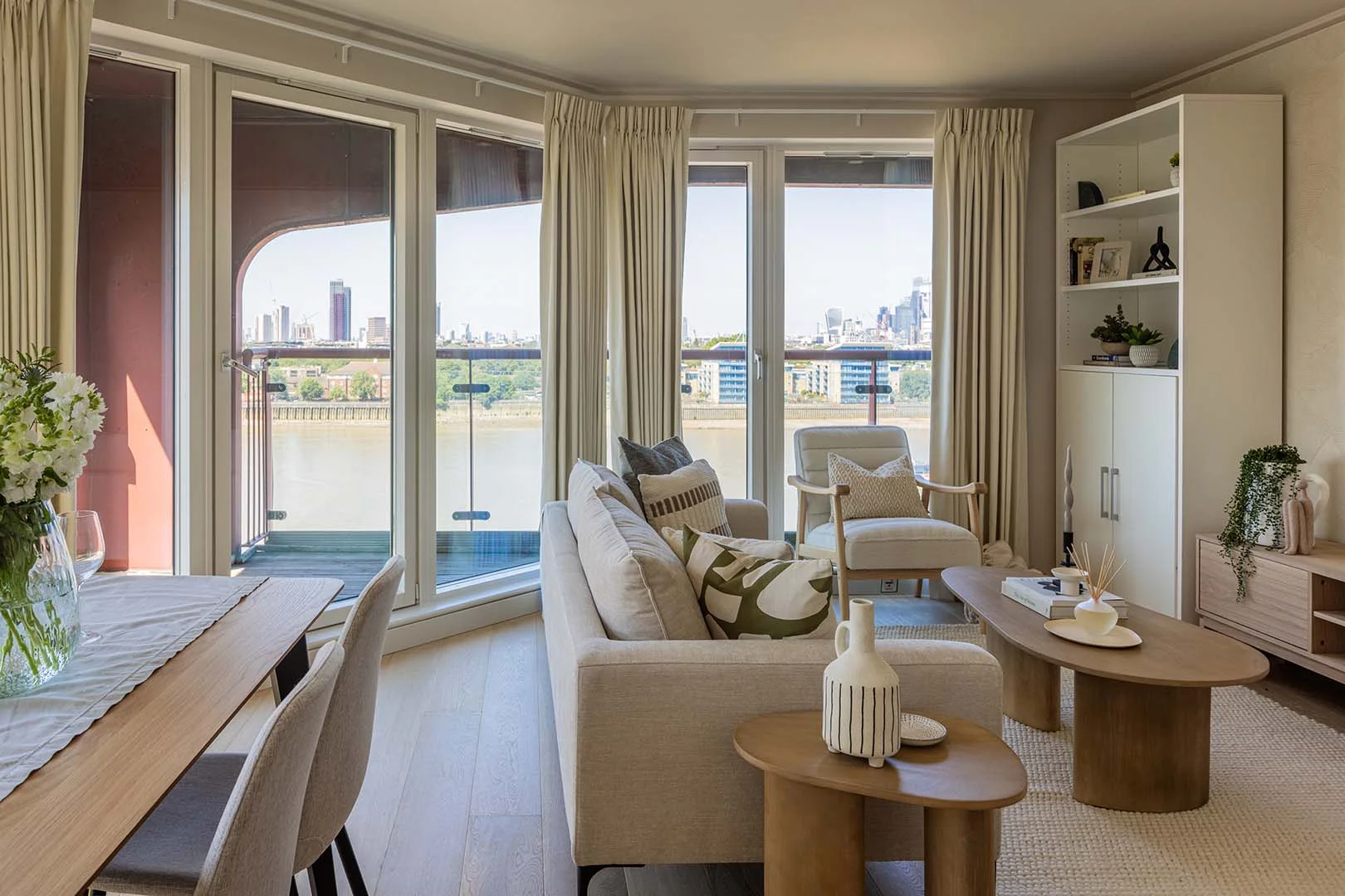 Modern furnished living room at Seacon Tower with floor-to-ceiling windows, Thames river views, neutral interiors, and contemporary furniture by InStyle Direct.