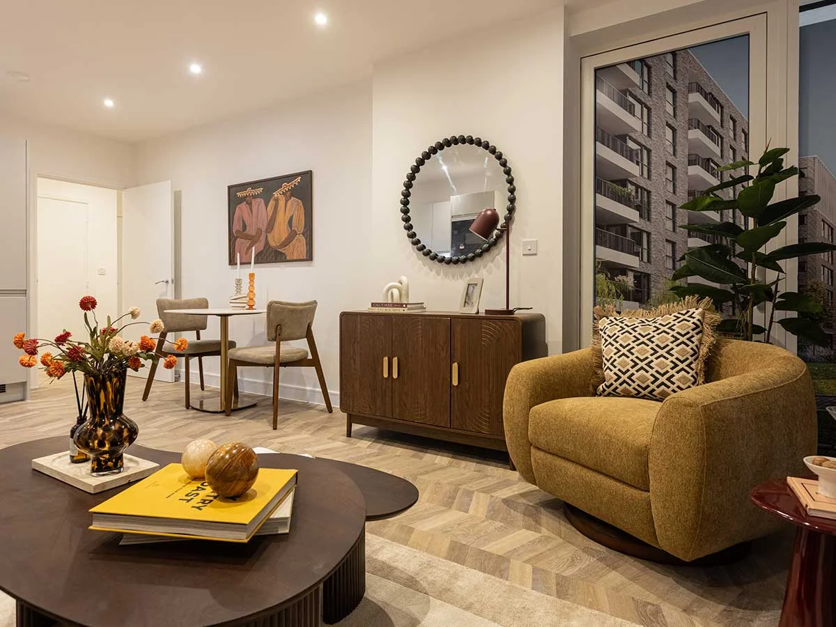 Modern living room at King George’s Gate with a mustard armchair and wooden sideboard.