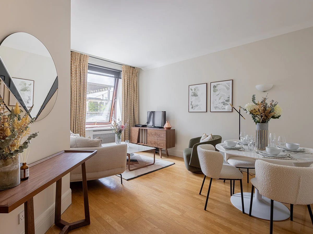 Modern furnished living and dining room with neutral furniture and wooden flooring