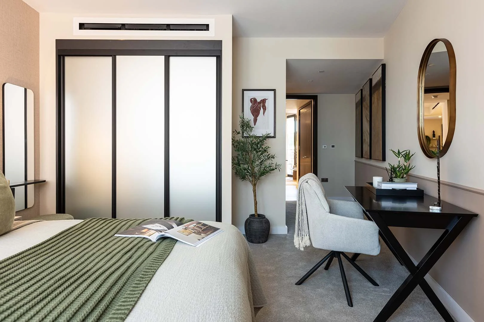 Stylish bedroom with built-in wardrobes, upholstered bed, workspace desk, and modern décor in a West End Gate apartment, Paddington London.