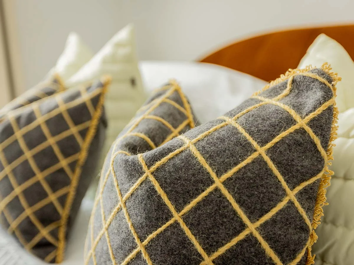 Close-up of decorative cushions on a styled bed in a furnished Horlicks Quarter apartment, showcasing contemporary bedroom styling and soft furnishings.