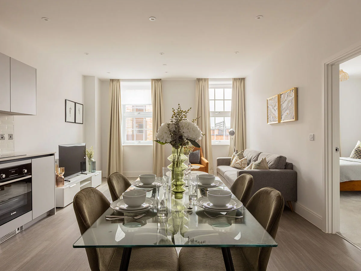 Open-plan kitchen, dining and living area in a furnished Horlicks Quarter apartment with contemporary furniture, modern kitchen and elegant interior styling.