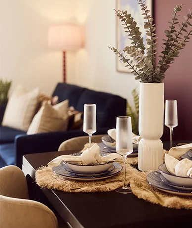 Close-up of a durable dining table setup styled by InStyle Direct for a Build to Rent apartment, featuring premium table dressings, textured placemats, and fine glassware