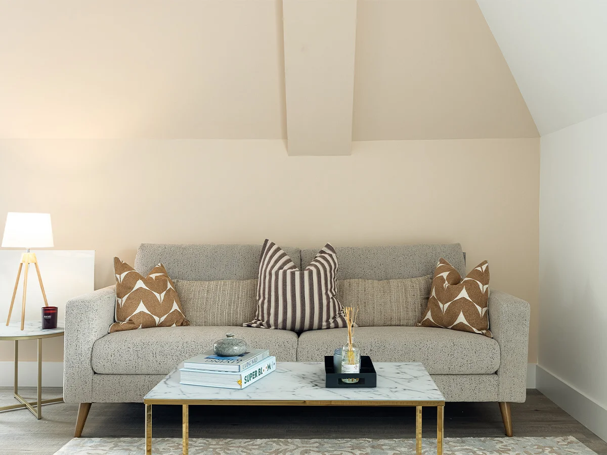 Modern sofa setup with cushions and coffee table from gold furniture package in apartment
