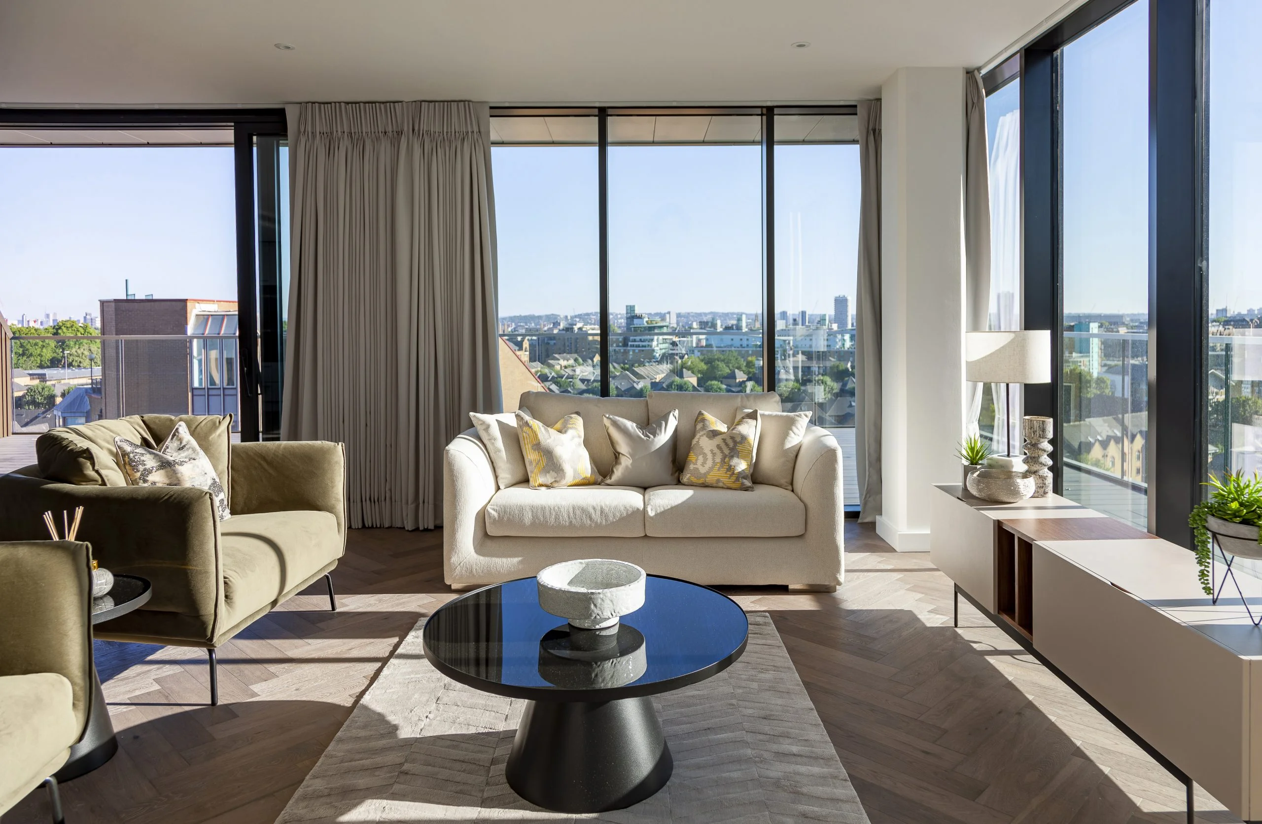 Modern living room in London Dock PRS apartment with large windows and city skyline views