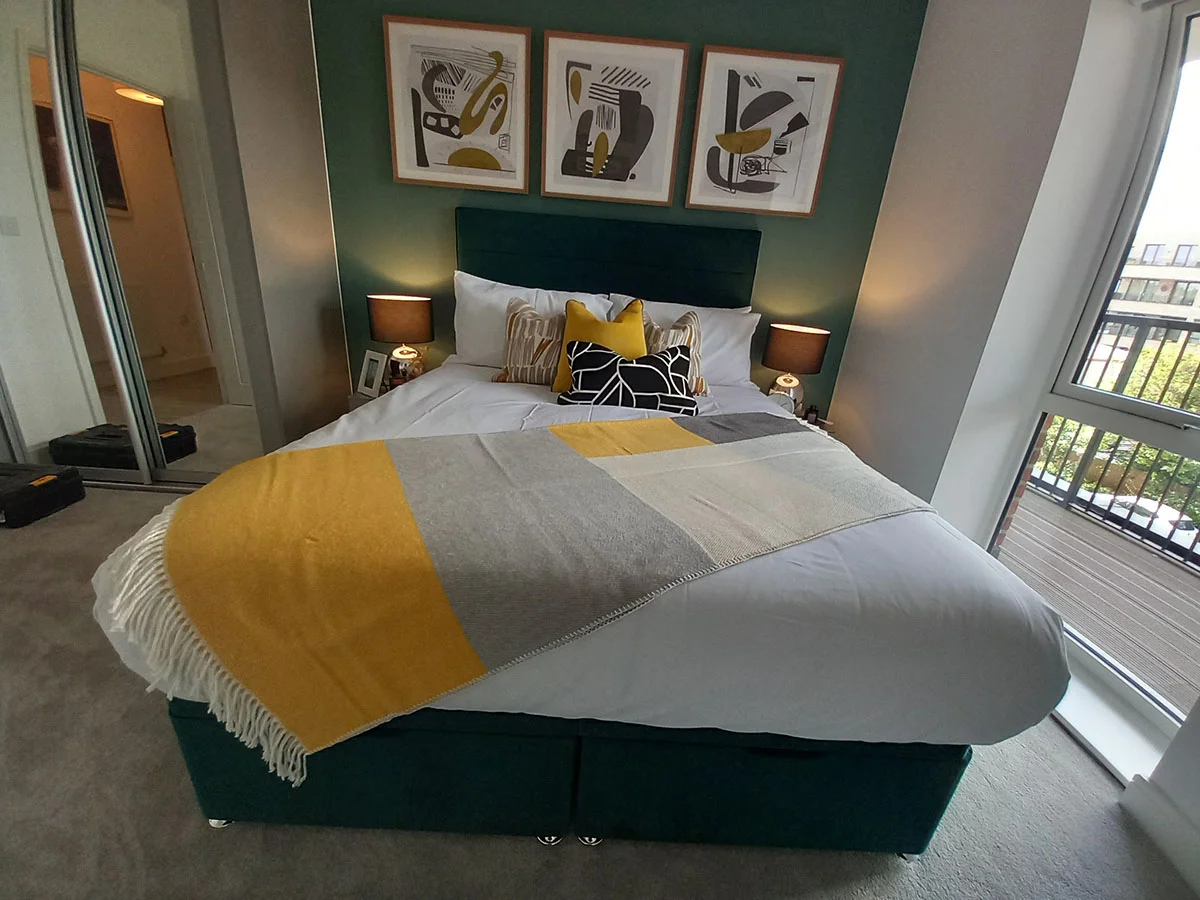 Luxury master bedroom featuring a velvet bed, feature wall, bedside tables and contemporary artwork as part of a London furniture package.