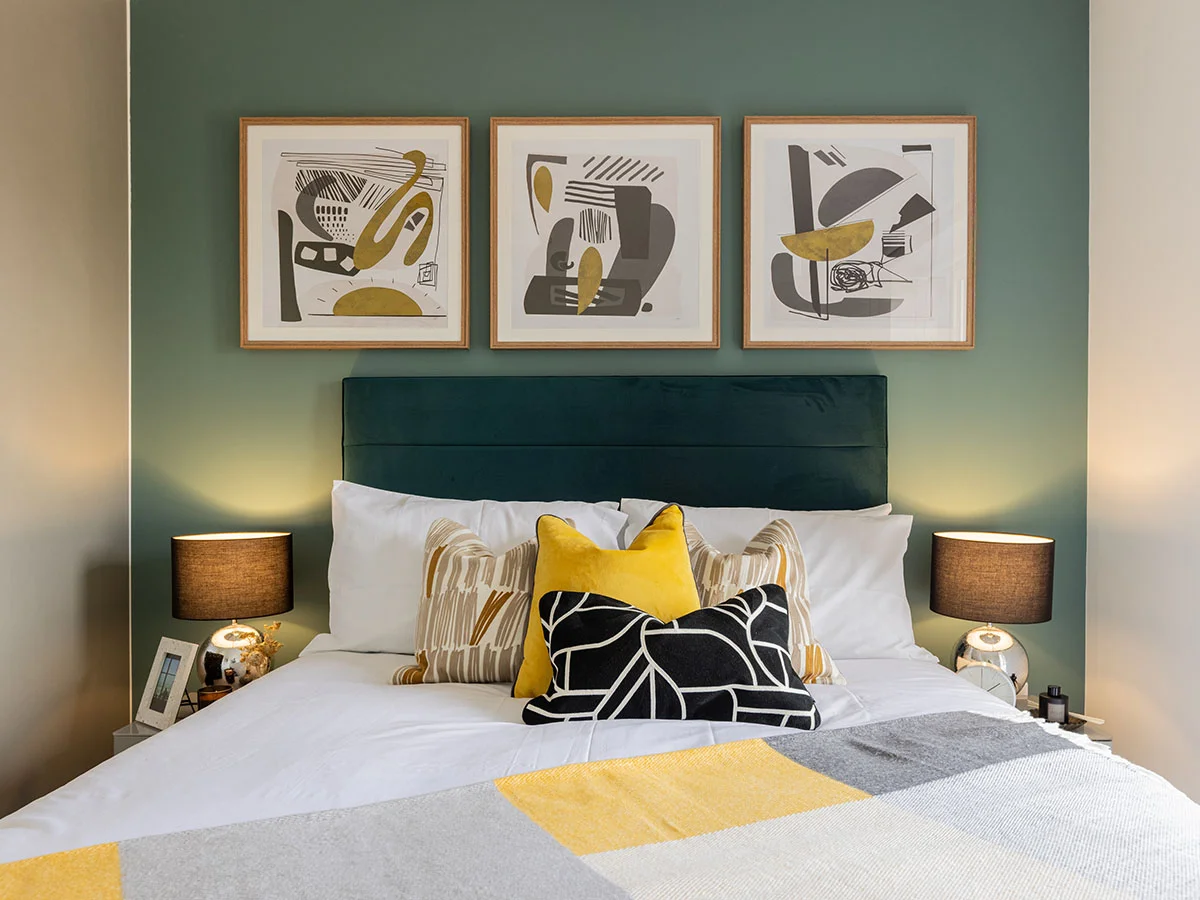 Stylish master bedroom featuring a green feature wall, upholstered bed, abstract artwork and coordinated soft furnishings in a London furniture package.