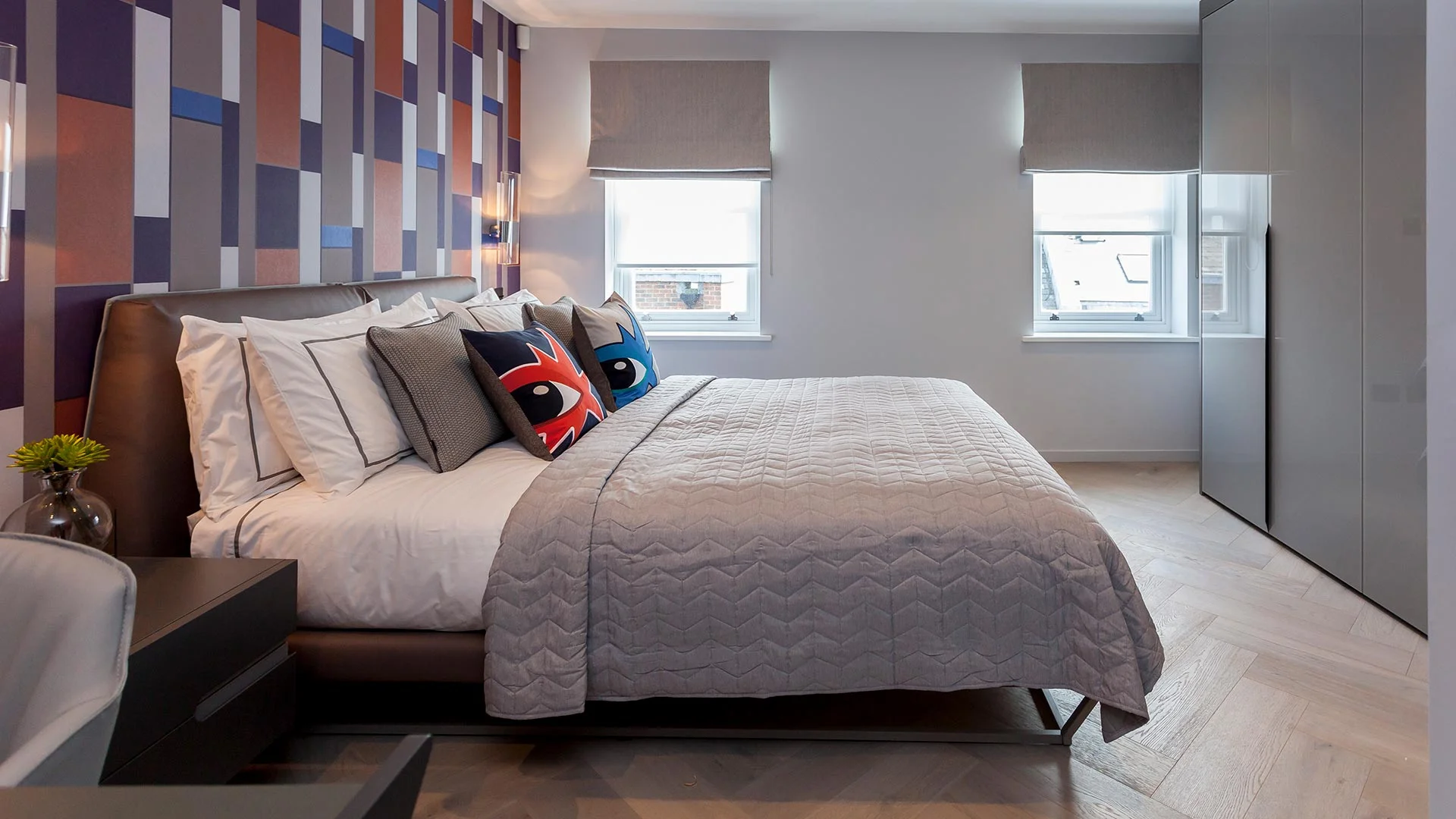 Modern roman blinds in luxury bedroom with stylish geometric wallpaper
