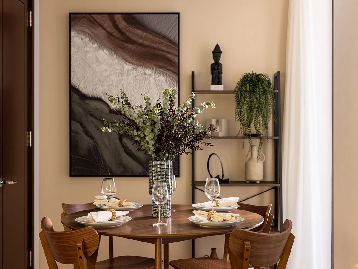 Contemporary dining area with round wooden table, decorative shelving, and elegant styling at West End Gate, London